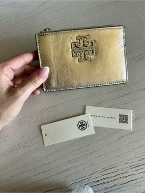 Tory Burch Shiny Gold Zip Card Wallet with silver zipper.